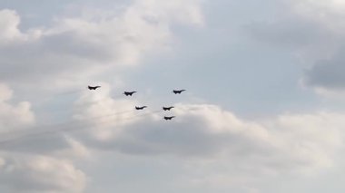 Mavi gökyüzünde altı savaş uçağı. Genel bir plan. Aerobatik figürler. Hava gösterisi. 12 saniye.