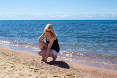 Gözlüklü sahilde oturan kız 