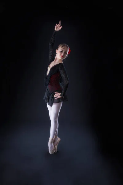 Bailarina de negro está bailando sobre un negro — Foto de Stock