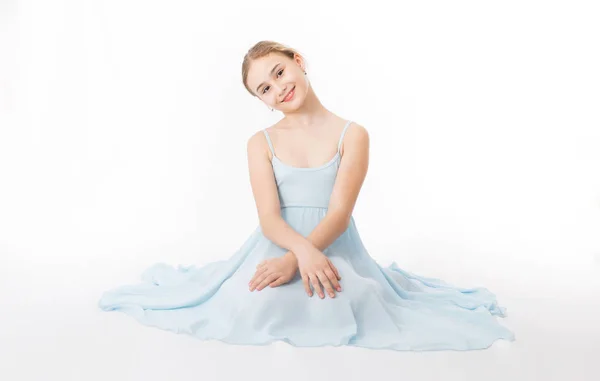 Girl in a blue dress is sitting — Stock Photo, Image