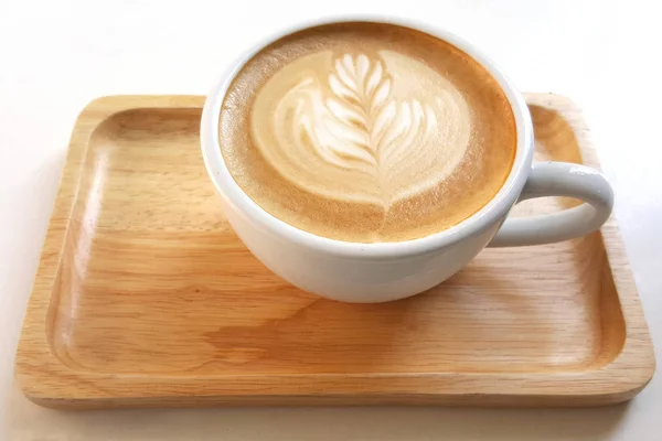 The mug of latte art coffee on wooden plate. — Stock Photo, Image