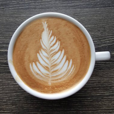 Bir fincan kahve latte sanat üstten görünüm ahşap arka plan üzerinde.