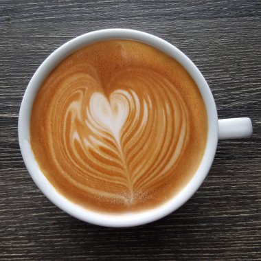 Bir fincan kahve latte sanat üstten görünüm ahşap arka plan üzerinde.