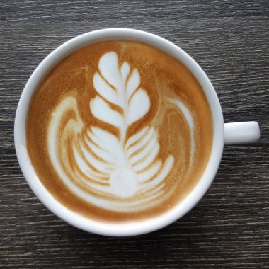 Bir fincan kahve latte sanat üstten görünüm ahşap arka plan üzerinde.