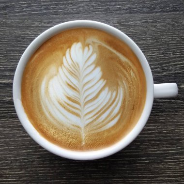 Bir fincan kahve latte sanat üstten görünüm ahşap arka plan üzerinde.