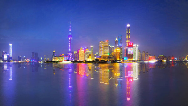 Shanghai city skyline Pudong side looking through Huangpu river on twilight time. Shanghai, China. Beautiful vibrant panoramic image.