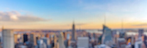 Blur background of New York City skyline from roof top with urban skyscrapers before sunset. New York, USA. Panorama image.
