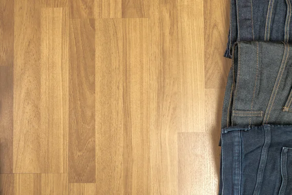 Jeans blu su fondo marrone in legno e jeans blu Col — Foto Stock