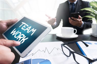 Ofis masasında çalışan ve bilgisayar ve nesneleri kullanan işadamı,