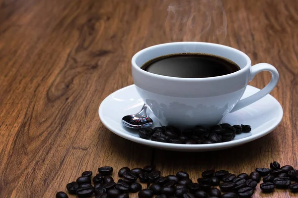 Kaffekopp och kaffebönor på bord, bryta eller frukost — Stockfoto