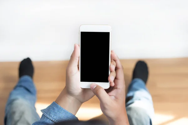 Cortado tiro de las manos del hombre sosteniendo el teléfono inteligente con copia en blanco — Foto de Stock