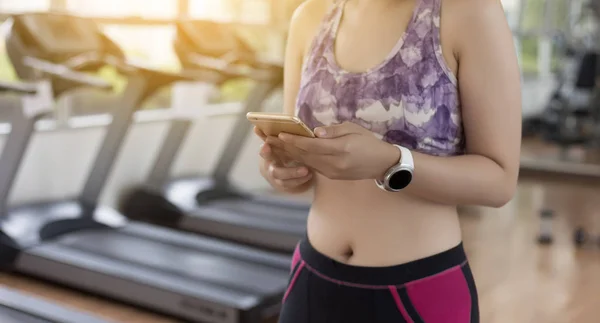 woman use phone  fitness exercise in gym smart gadgets and sport