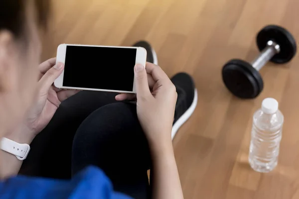 woman use phone  fitness exercise in gym smart gadgets and sport