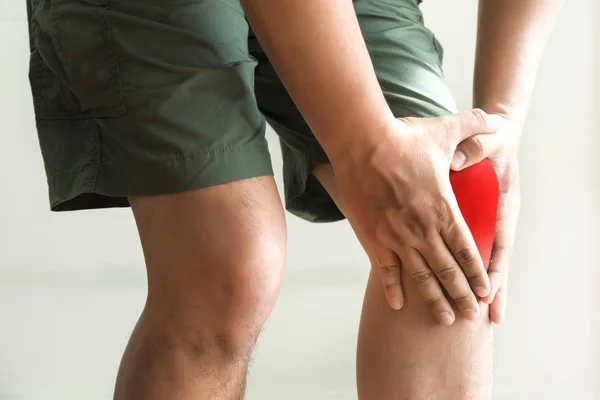 Ο άνθρωπος γόνατο κρατά υποφέρουν από πόνο στο γόνατο κινηματογράφηση σε πρώτο πλάνο. Το l — Φωτογραφία Αρχείου