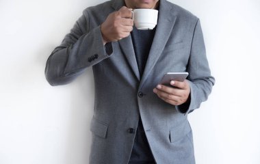 adam telefonu mutlu kullanabilir ve kahve ve beyaz arka plan ile gülümsemek 