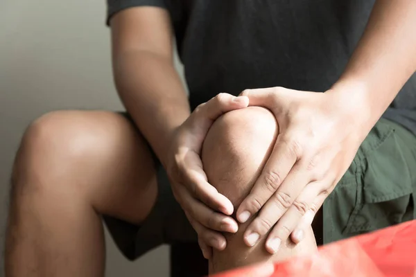 The knee man holds on suffering from pain in knee Closeup. — Stock Photo, Image