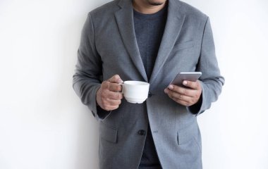 adam telefonu mutlu kullanabilir ve kahve ve beyaz arka plan ile gülümsemek 