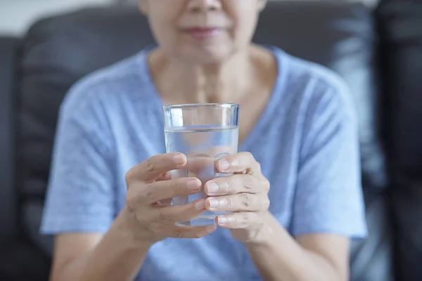 Portrait  Elderly woman  drinking glass of water to retirement i