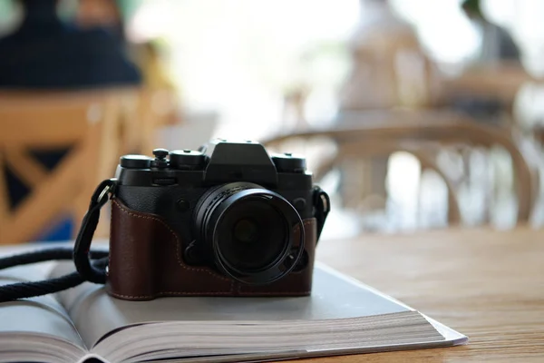 Alte Kamera auf Buch auf Tisch Café Hintergrund — Stockfoto