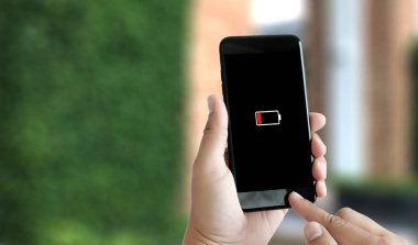 Akıllı telefon pil şarjlı pil kullanarak adam ellerini kapatın