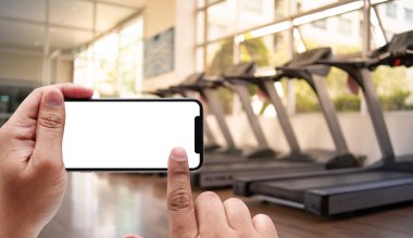 Smartphone spor salonunda fitness telefon fitne için tutan el genç adam
