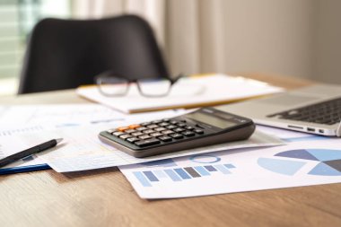İş adamı, hesap makinesi strateji analizi kullanarak finansal belge veri grafiklerini analiz etmeyi planlıyor.