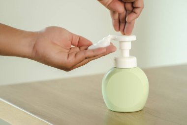 Adam sabun kullanarak ellerini yıkıyor ve coronavirüs enfeksiyonunu önlüyor.