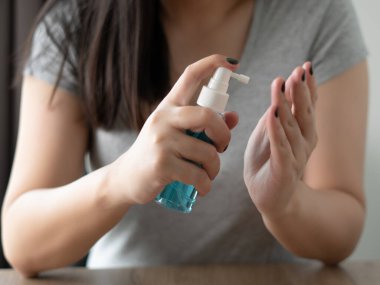 Kadın ellerini dezenfektan virüsüne temizliyor ve kovid 19 virüsünün alkol jeli veya antibakteriyel püskürmesini engelliyor.