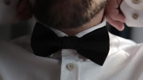 Hombre ajusta su corbata en una camisa blanca . — Vídeo de stock