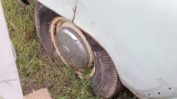 Εγκαταλελειμμένο σπασμένο αυτοκίνητο που καλύπτεται με χώμα και πράσινο κοντά — Αρχείο Βίντεο