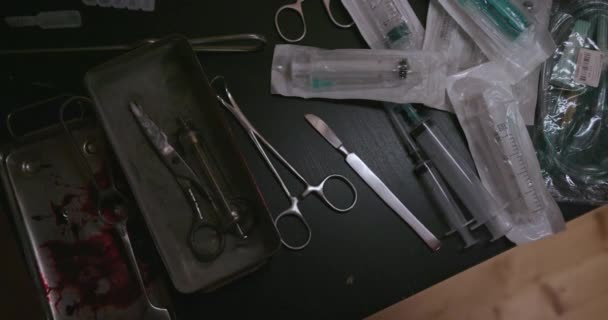 Een vrouw neemt een scalpel op tafel. Spuiten, chirurgische instrumenten — Stockvideo