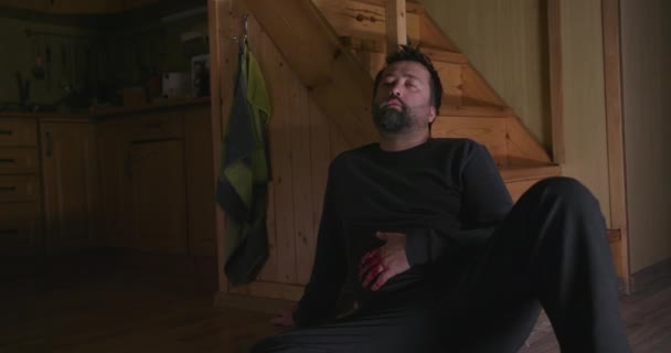 Uomo ferito nel sangue seduto sul pavimento — Video Stock