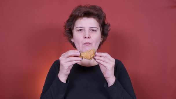 Mujer joven comiendo pollo frito — Vídeos de Stock