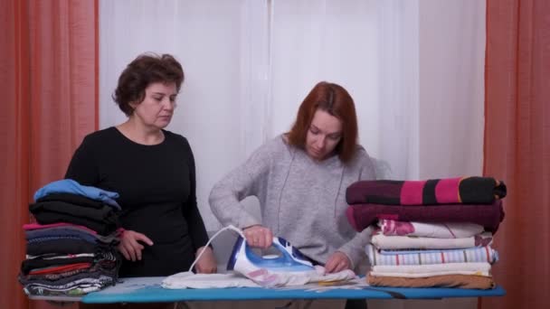 Woman teaches to iron. She is teaching woman to iron. — Stock Video