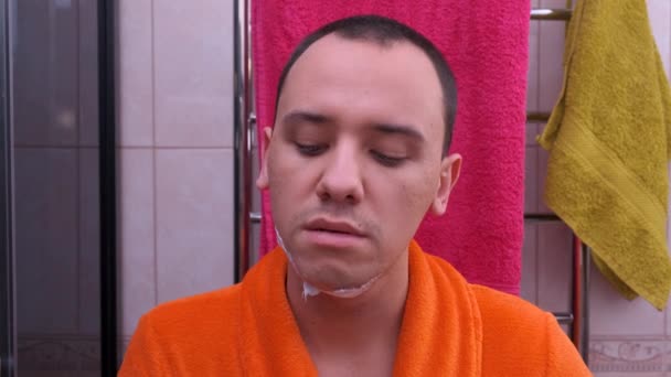 Uomo mette la crema da barba sul suo viso in bagno — Video Stock