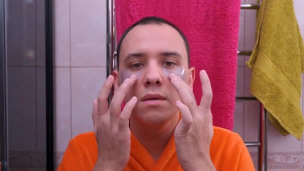 Mannen använder fläckar under hennes ögon i badrummet. — Stockvideo