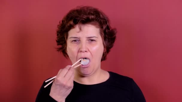 Vrouw sushi eten met stokjes — Stockvideo