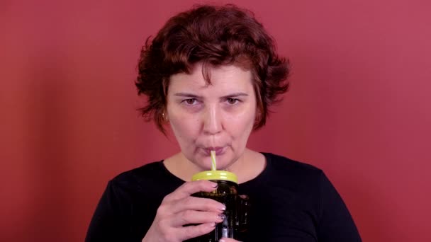 Vrouw drinkt een frisdrank door een cactus glas — Stockvideo