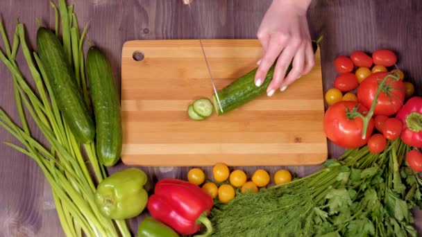 Vista superior de las manos de una mujer cortando pepino . — Vídeo de stock