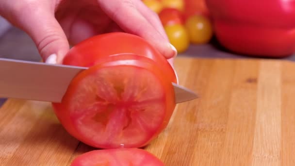 Закрыть руки женщины режут помидоры — стоковое видео
