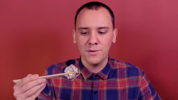 Muž se podívá na sushi a chce ho sníst — Stock video