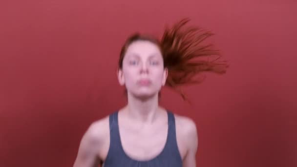 Mujer atlética joven con pelo rojo corre — Vídeos de Stock