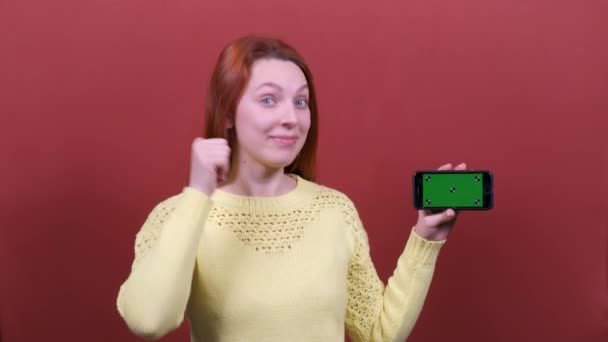 Redhead woman holding mobile phone with empty chromakey c. People sincere emotions, lifestyle concept. — Stock Video