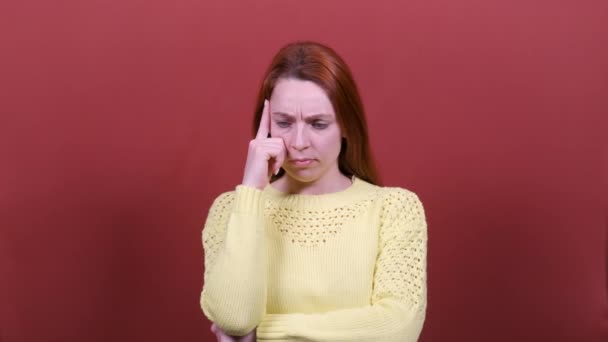 Femme rousse regarde la caméra, pense, se mord la lèvre, trouve des idées. Les gens émotions sincères, concept de style de vie . — Video