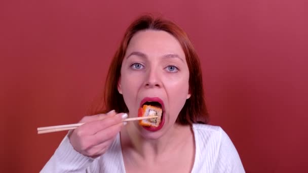 Zrzka Mladá žena jí sushi s hůlkami. — Stock video