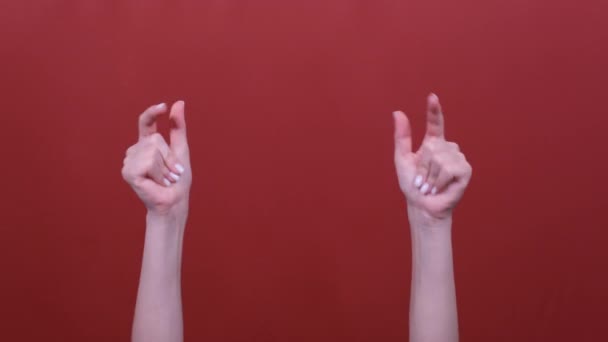Woman hand snaps her fingers to music rhythm gesture isolated over red background in studio — Stock Video