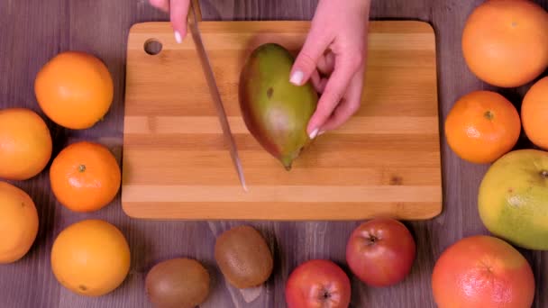 Frauenhände schneiden frische Mango in Küche — Stockvideo