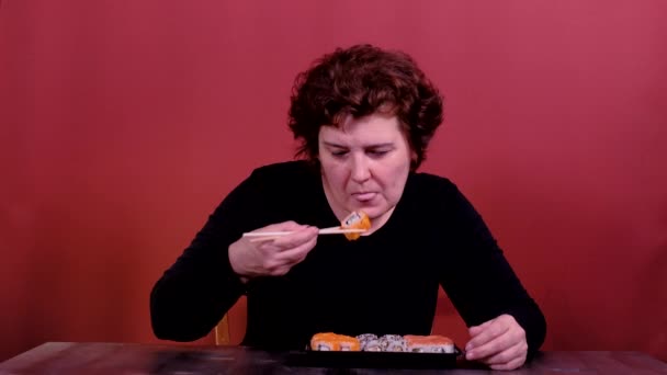 Mujer comiendo sushi con palillos — Vídeos de Stock