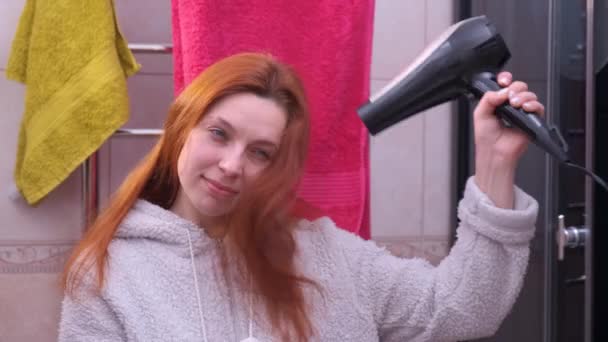 Fiatal nő szárítás a haját, fürdőszoba — Stock videók