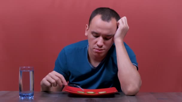 Fiatal férfi érzés szomorú és unatkozik a diéta nem akar enni zöldség vagy egészséges étel fogyókúra zavarok és fogyás koncepció. — Stock videók